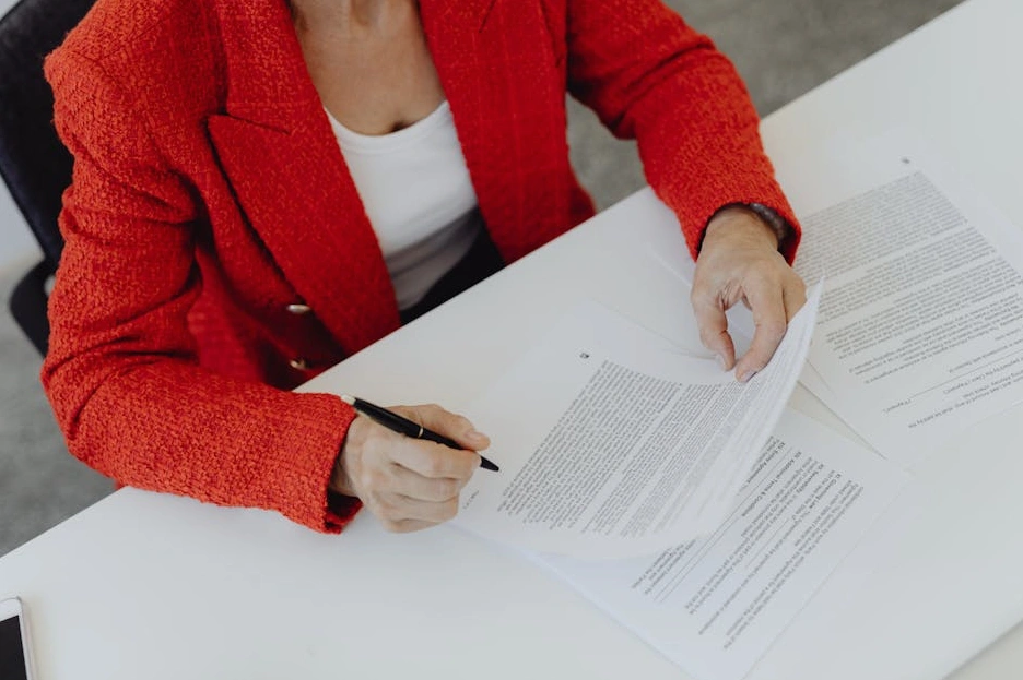 Osoba podpisująca ważny dokument, symbolizujący decyzję o rozwoju